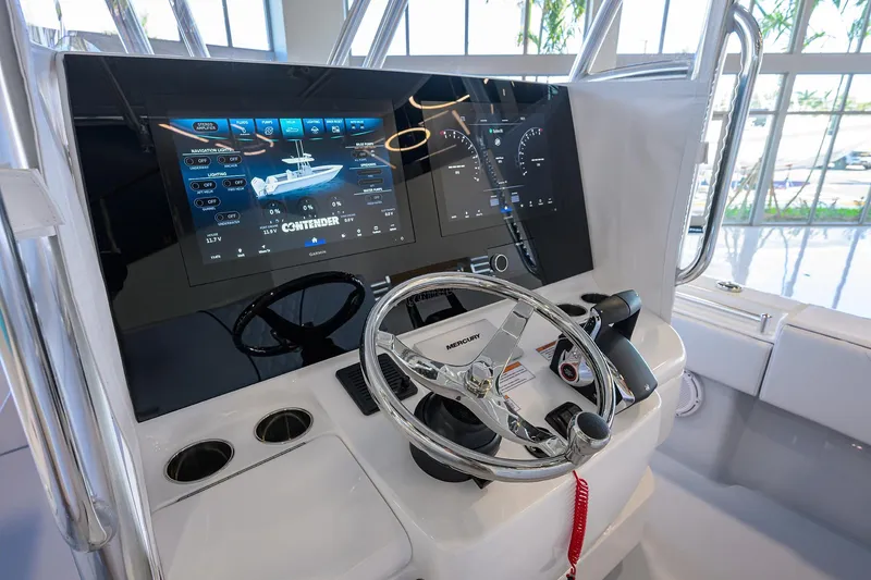 Slide: The Image of 2025 Contender 32 ST boat dashboard with advanced digital displays and steering wheel. - 6