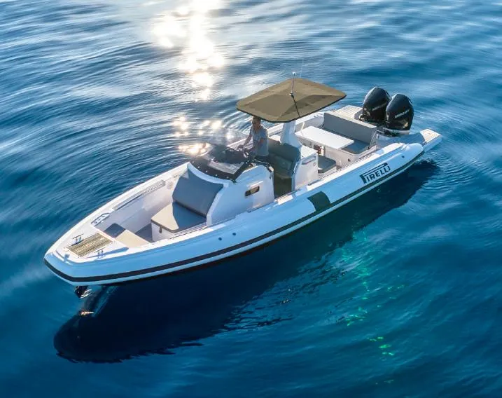 Slide: The Image of 2025 Pirelli 30 boat cruising on clear blue water, featuring sleek design and twin engines. - 2