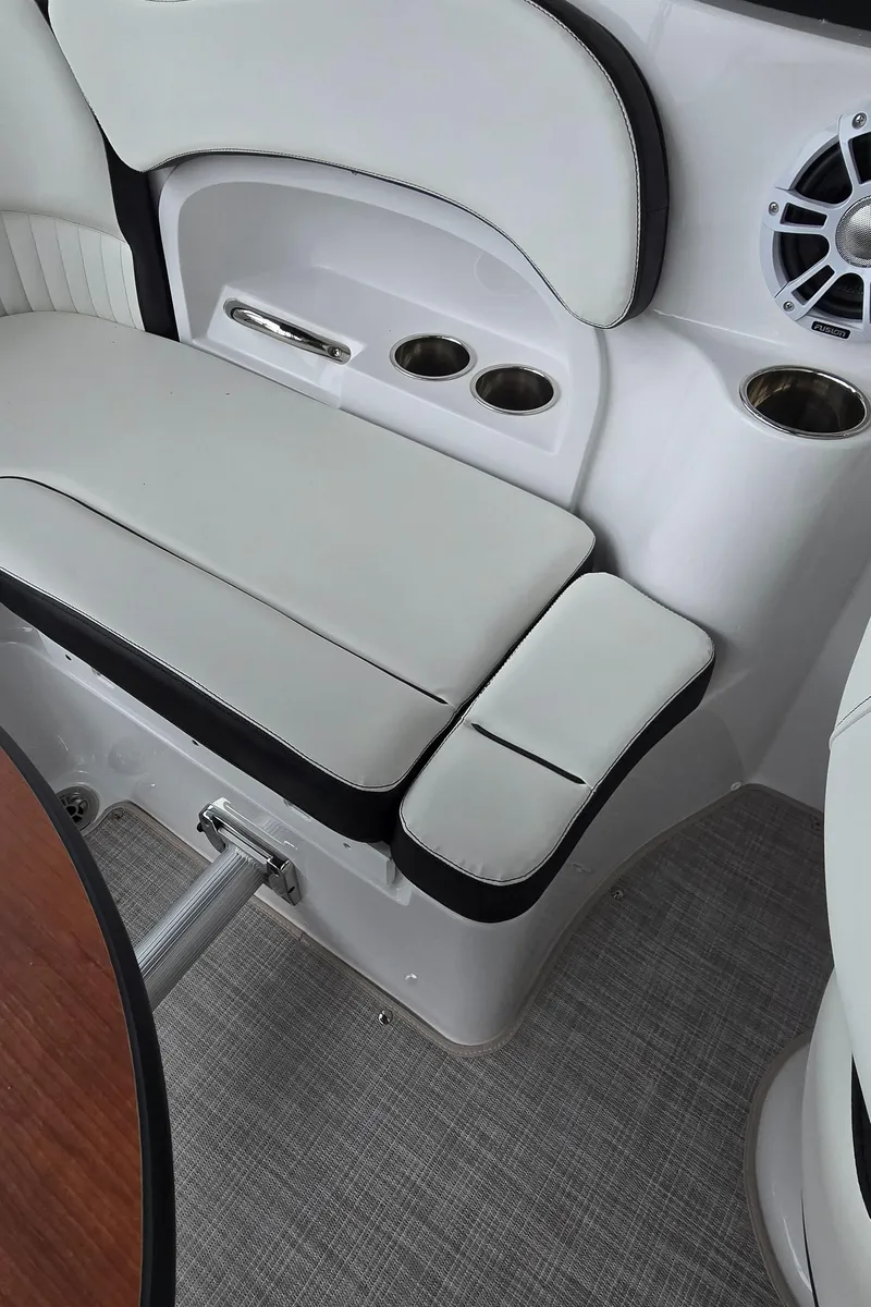 Slide: The Image of 2025 Stingray 211DC boat interior with white seating, cup holders, and speaker. - 11