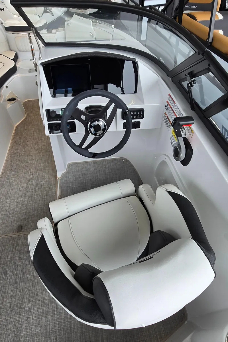 Slide: The Image of 2025 Stingray 211DC boat cockpit with modern steering and comfortable seating. - 12