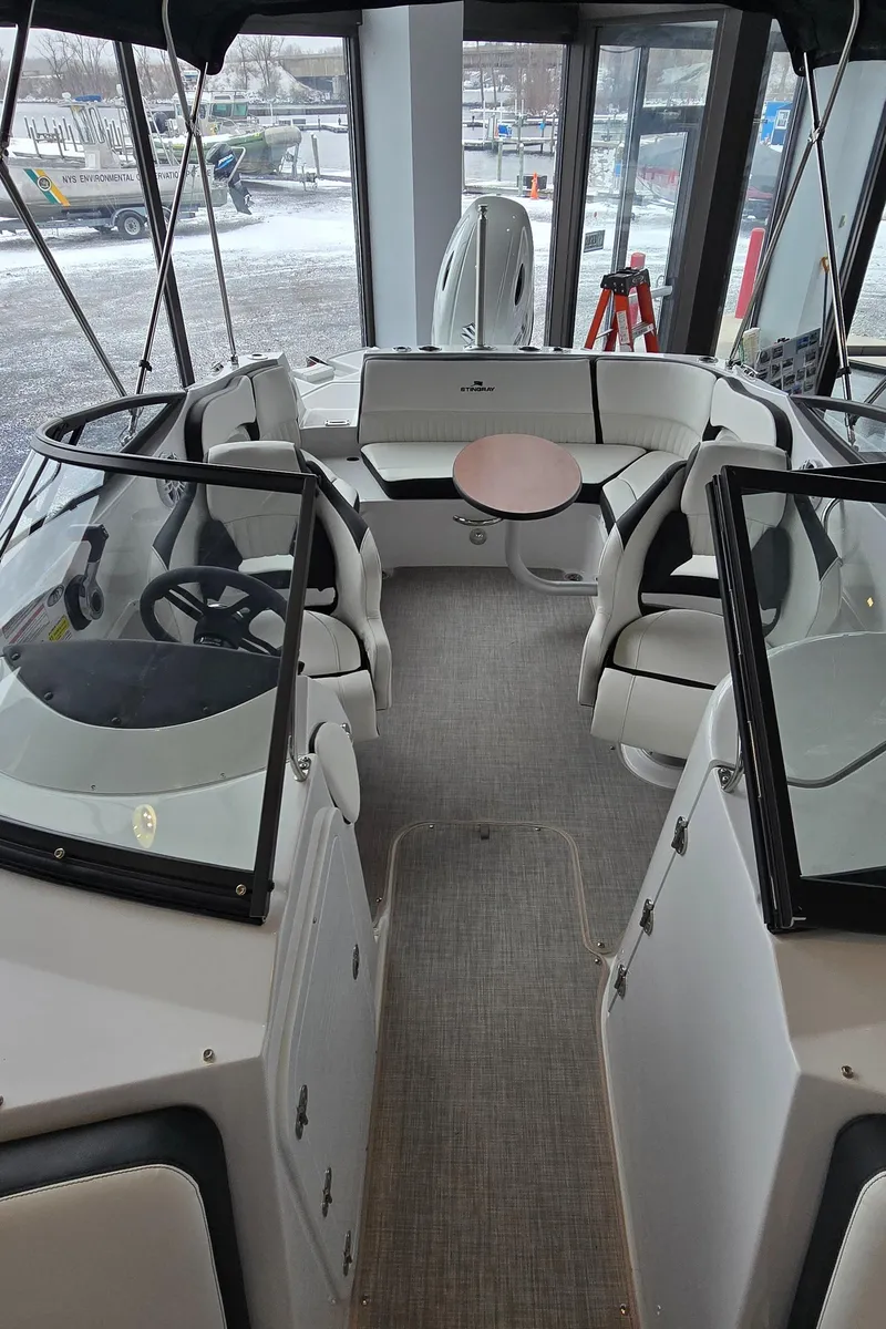 Slide: The Image of 2025 Stingray 211DC boat interior with seating and steering wheel. - 14