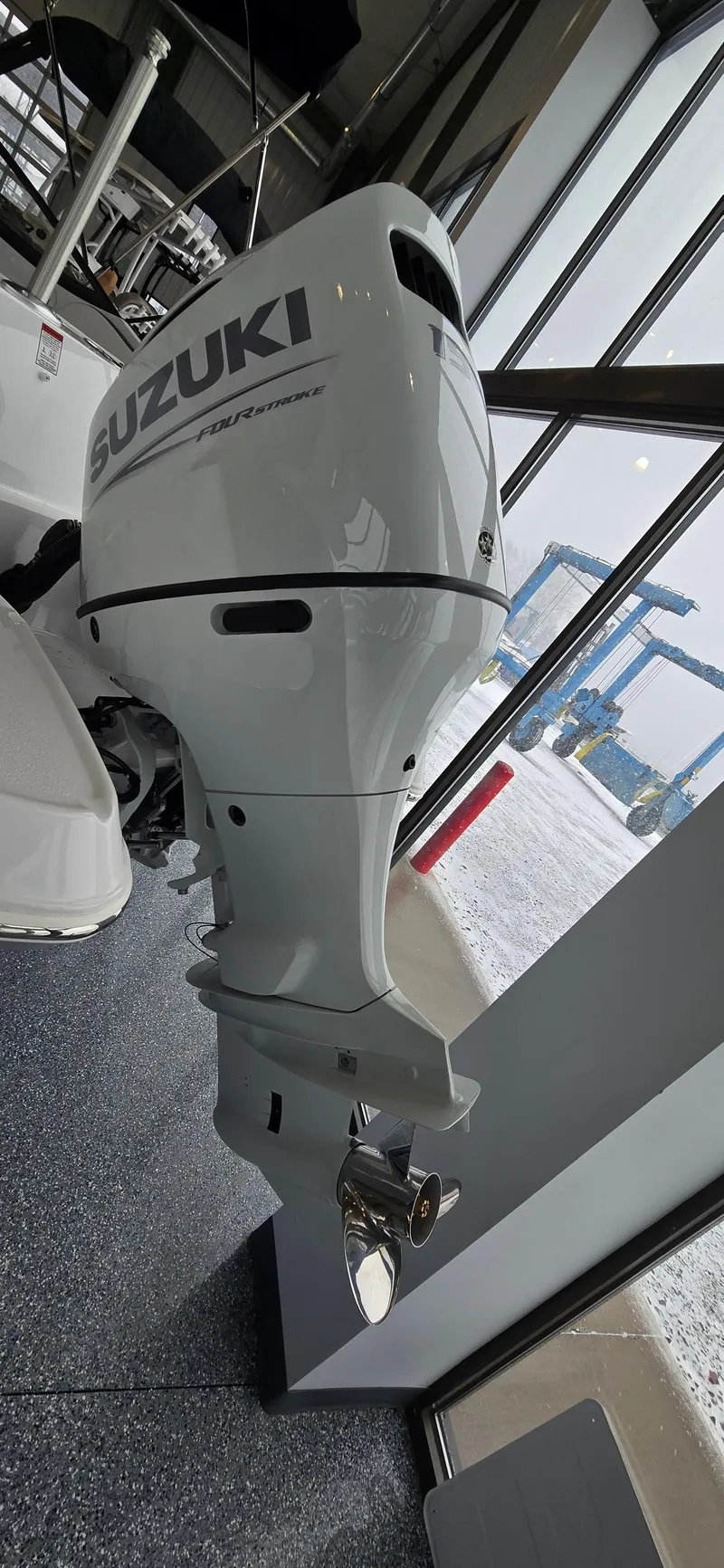 Slide: The Image of 2025 Stingray 211DC with Suzuki outboard motor in showroom display. - 18