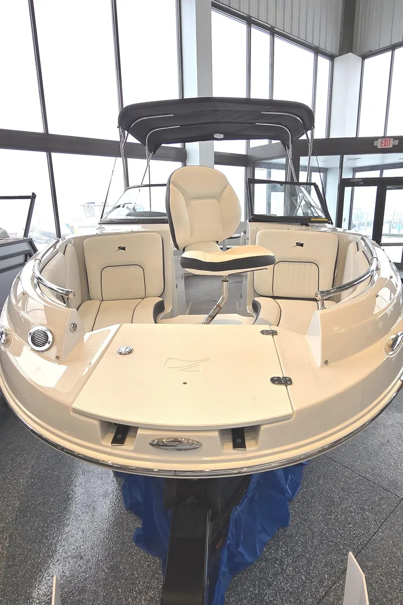 Slide: The Image of 2025 Stingray 211DC boat in showroom, featuring sleek design and comfortable seating. - 2