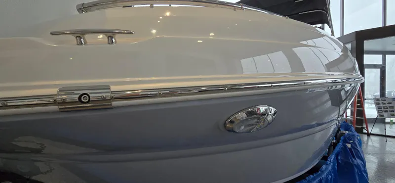 Slide: The Image of 2025 Stingray 211DC boat, sleek design, showcased indoors with reflective windows. - 20