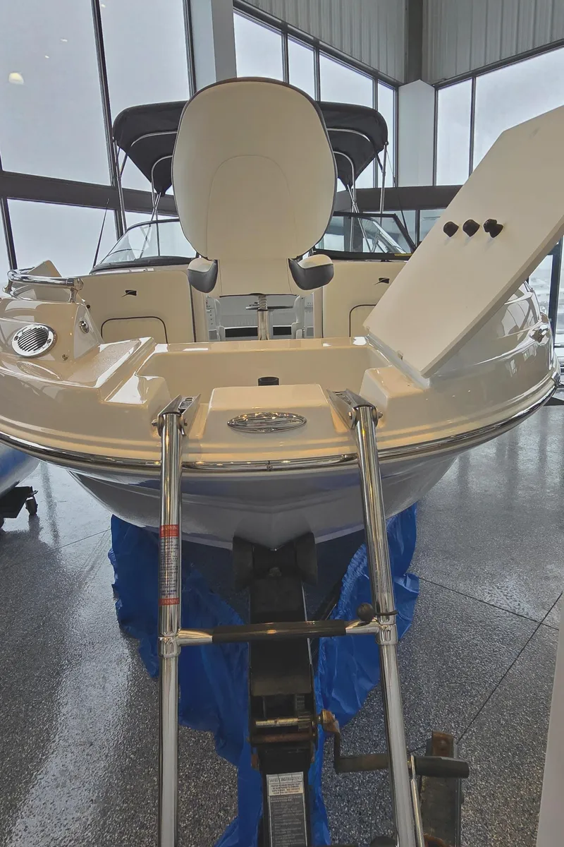 Slide: The Image of 2025 Stingray 211DC boat in showroom, rear view with ladder and seating. - 23