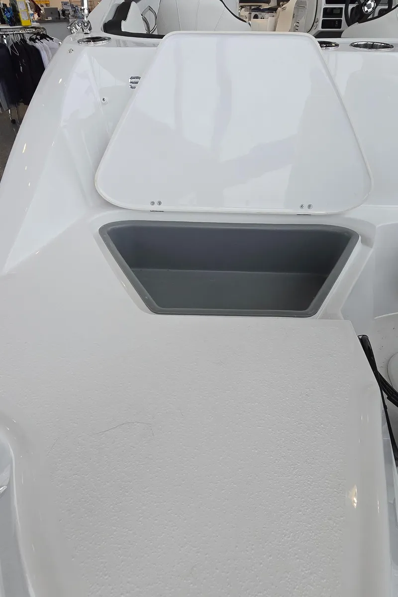 Slide: The Image of 2025 Stingray 211DC boat interior with storage compartment, white finish. - 26