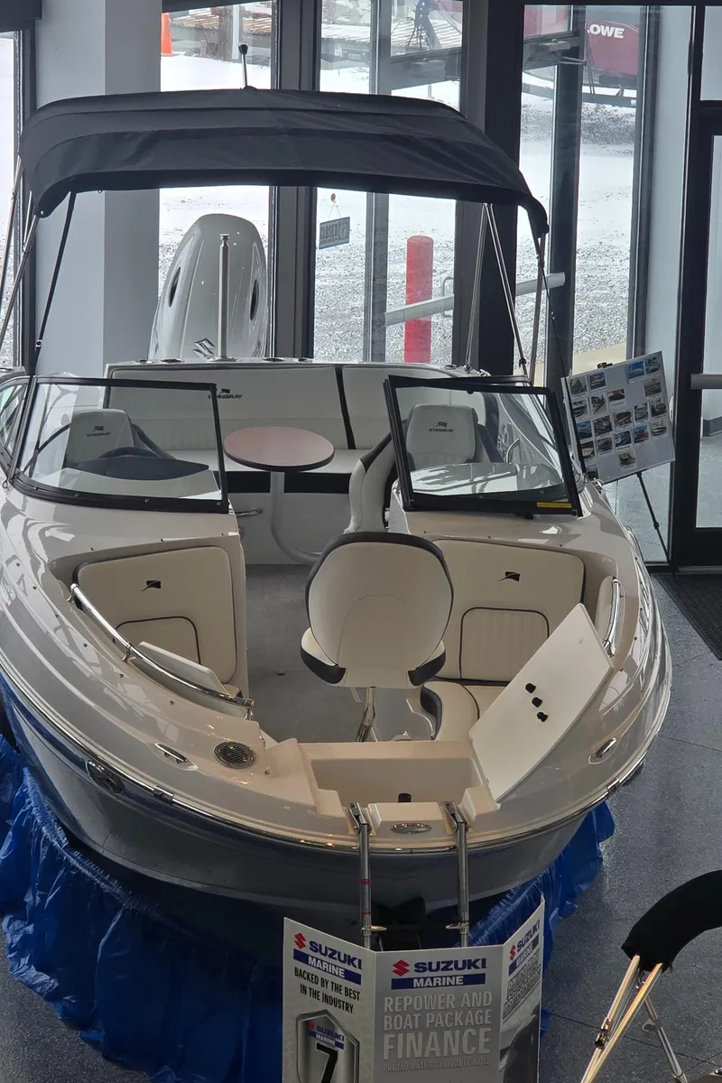 Slide: The Image of 2025 Stingray 211DC boat displayed indoors with promotional materials. - 3