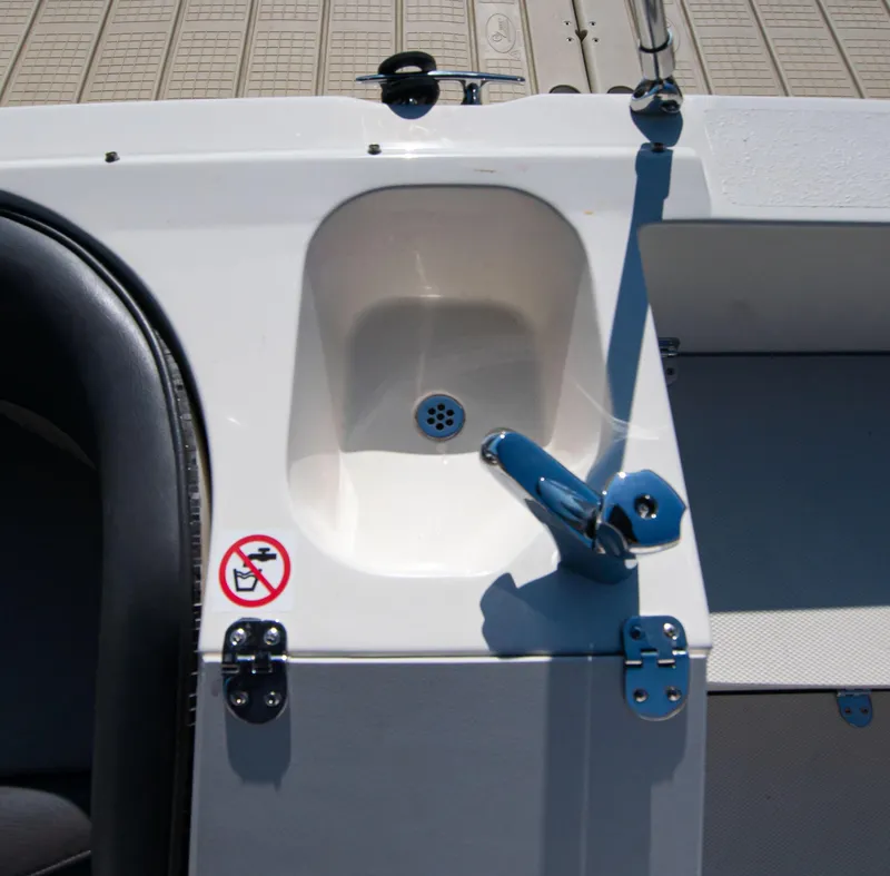Slide: The Image of 2019 Stingray 212 SC boat sink with faucet and no smoking sign. - 12