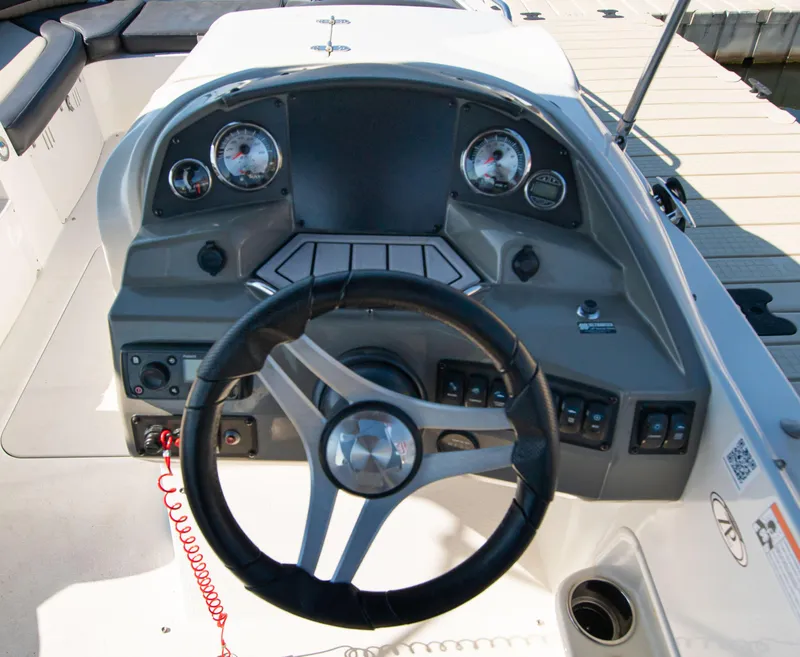 Slide: The Image of 2019 Stingray 212 SC boat dashboard with steering wheel and gauges. - 18