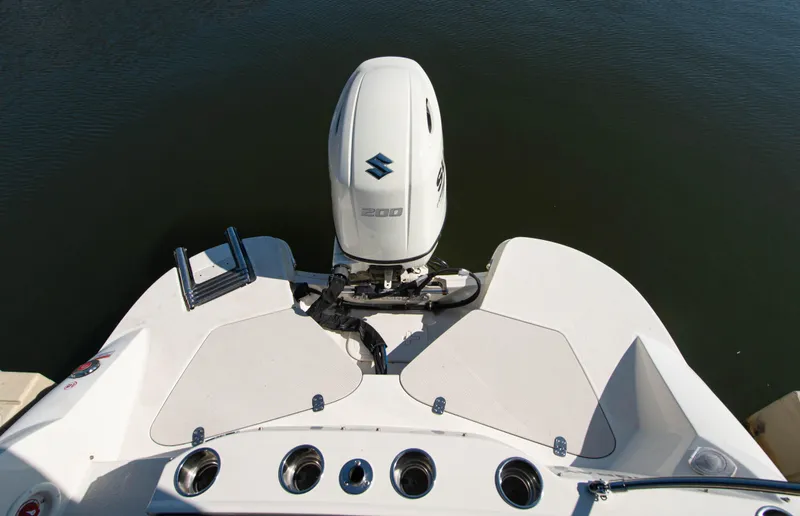 Slide: The Image of 2019 Stingray 212 SC boat with Suzuki outboard motor on calm water. - 19