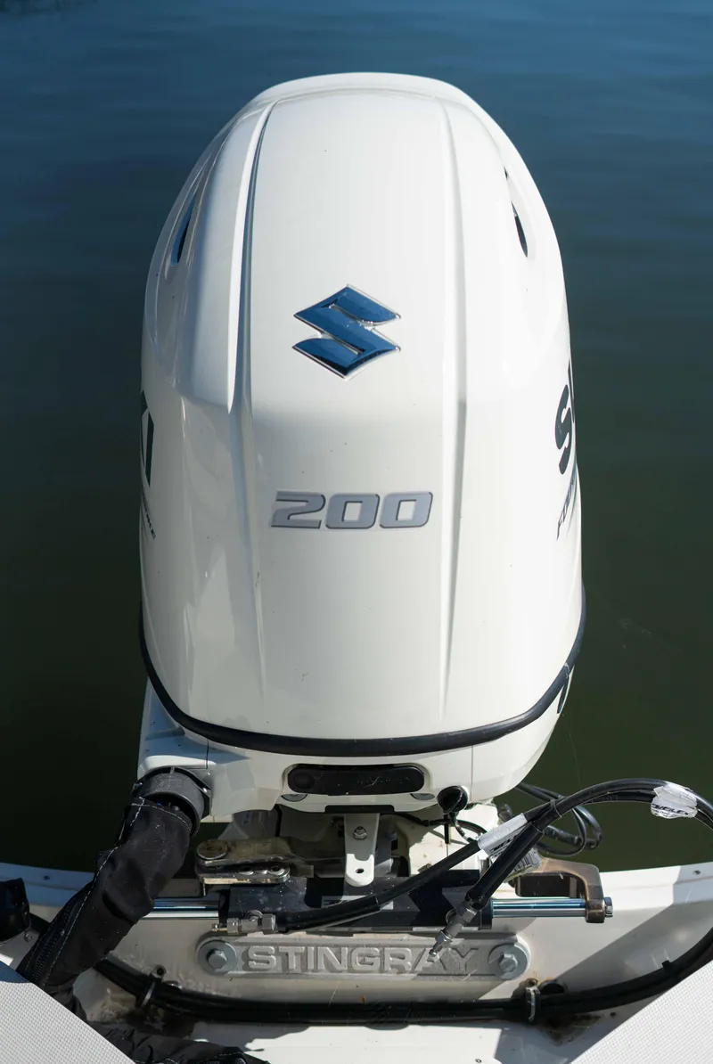 Slide: The Image of 2019 Stingray 212 SC boat with Suzuki 200 outboard motor on water. - 25
