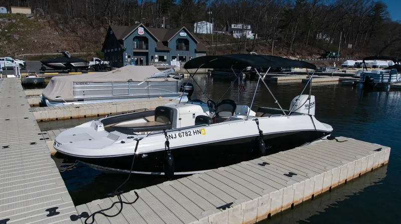 Slide: The Image of 2019 Stingray 212 SC boat docked at a marina with covered seating. - 3