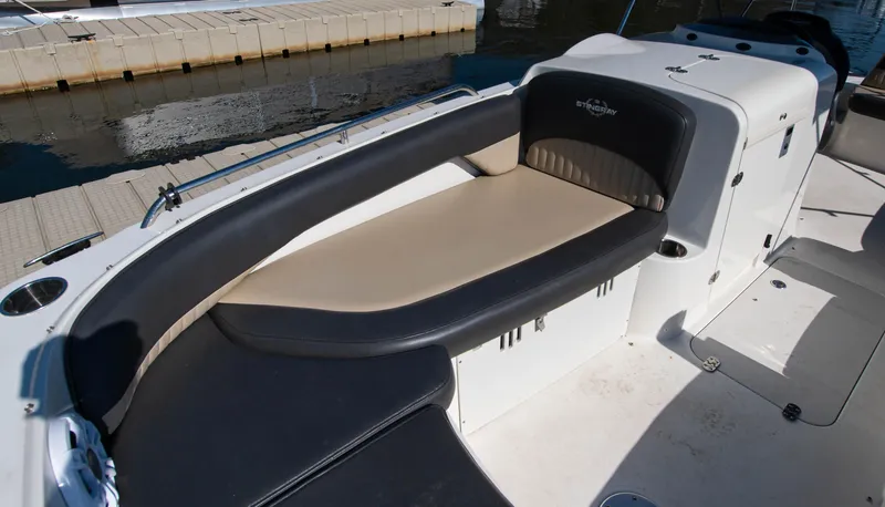 Slide: The Image of 2019 Stingray 212 SC boat interior with cushioned seating and storage. - 9