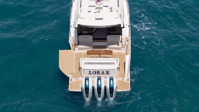 Slide: The Image of 2024 Tiara Yachts 48 LE with triple outboard engines on blue ocean water. - 13