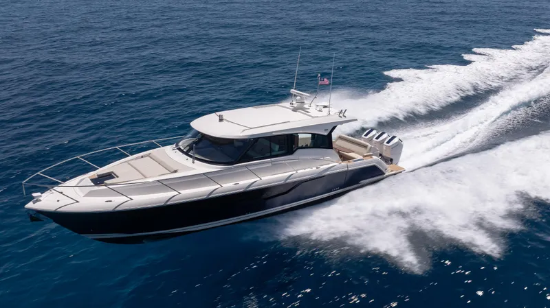 Slide: The Image of 2024 Tiara Yachts 48 LE cruising on open water, creating a dynamic wake. - 2