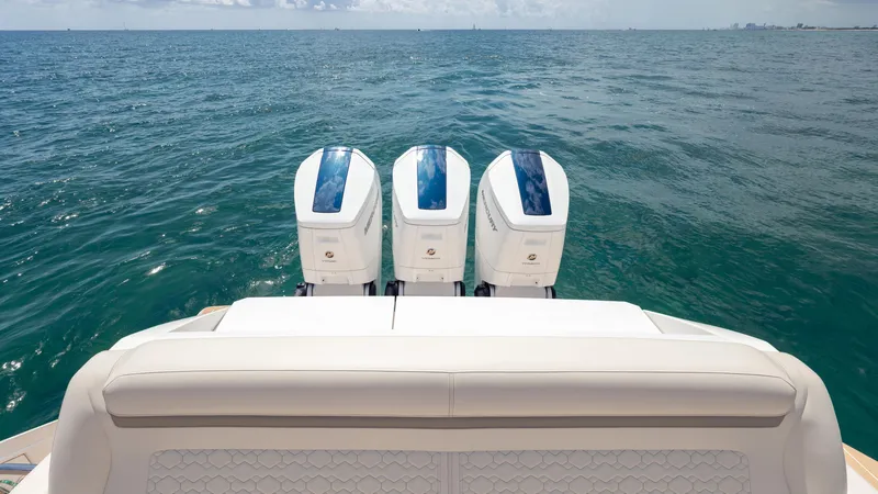 Slide: The Image of 2024 Tiara Yachts 48 LE with triple outboard engines on open sea. - 22