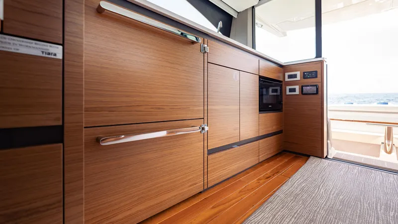 Slide: The Image of 2024 Tiara Yachts 48 LE interior with sleek wooden cabinetry and modern appliances. - 36