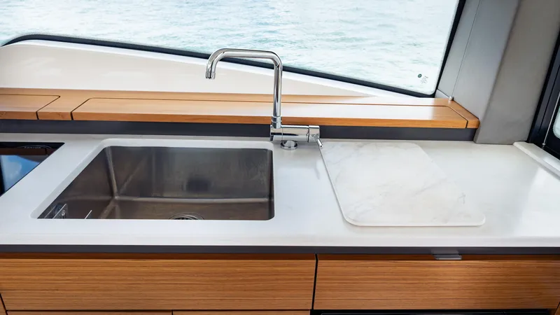Slide: The Image of 2024 Tiara Yachts 48 LE kitchen sink with modern faucet and wooden cabinetry. - 44