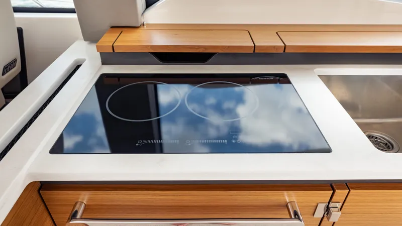 Slide: The Image of Modern kitchen area on 2024 Tiara Yachts 48 LE, featuring sleek induction cooktop. - 45