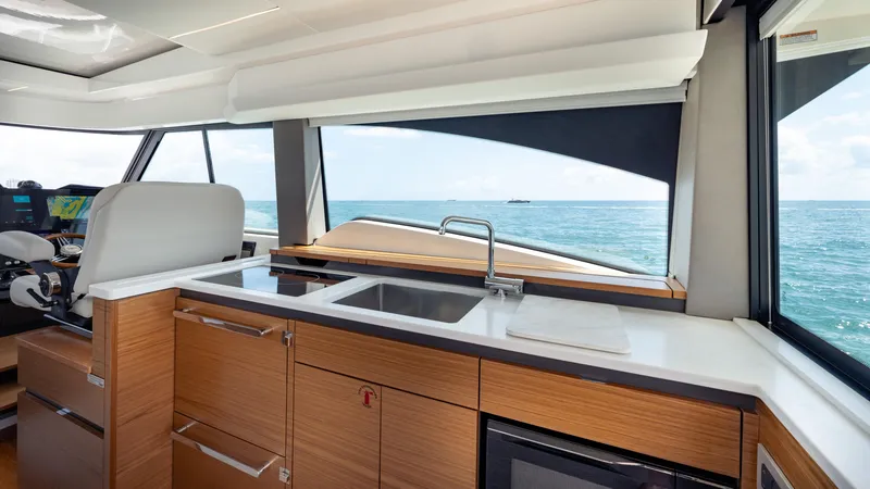 Slide: The Image of 2024 Tiara Yachts 48 LE interior with modern kitchen and ocean view. - 47