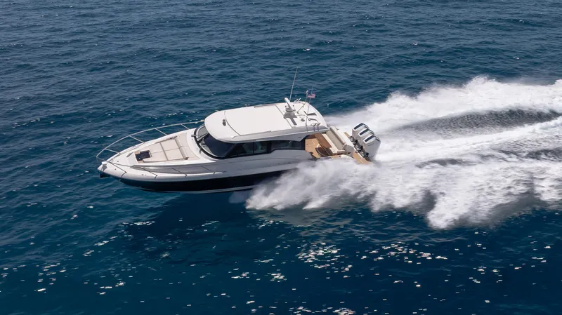 Slide: The Image of 2024 Tiara Yachts 48 LE cruising on open ocean, creating dynamic water trails. - 7