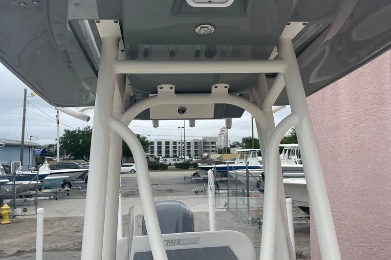 Slide: The Image of 2024 Pathfinder 2200 TRS boat with T-top frame, docked near other boats. - 16