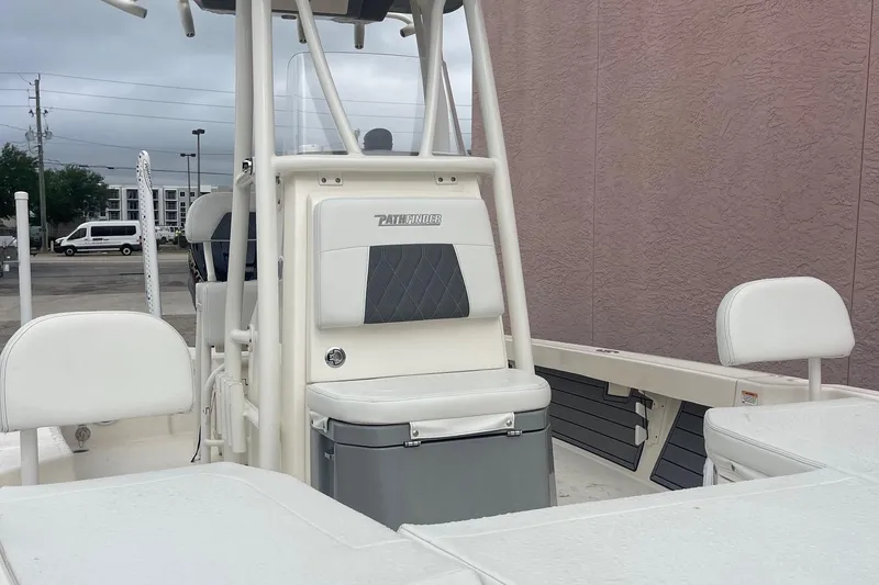 Slide: The Image of 2024 Pathfinder 2200 TRS boat interior with seating and storage, parked outdoors. - 17