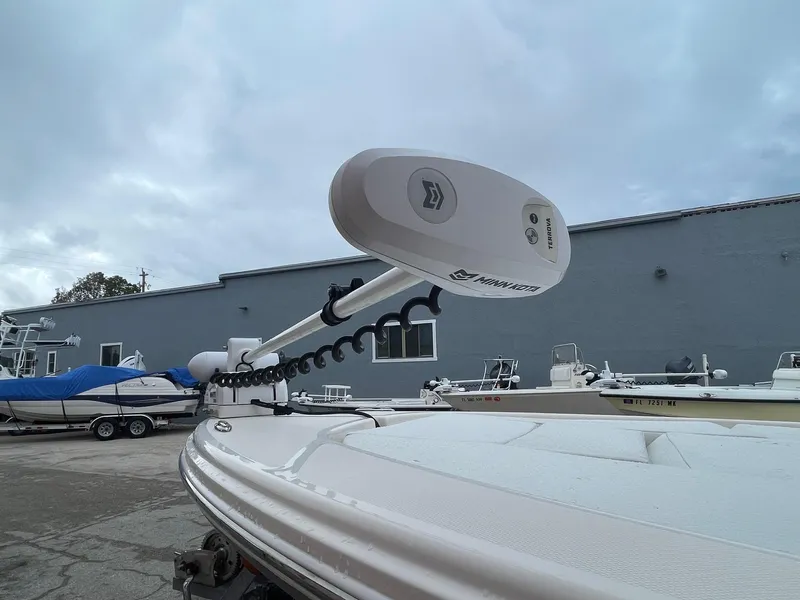 Slide: The Image of 2024 Pathfinder 2200 TRS boat with trolling motor in a marina setting. - 4