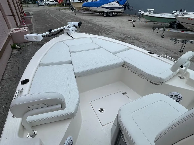 Slide: The Image of 2024 Pathfinder 2200 TRS boat interior with white cushioned seating and storage compartments. - 5