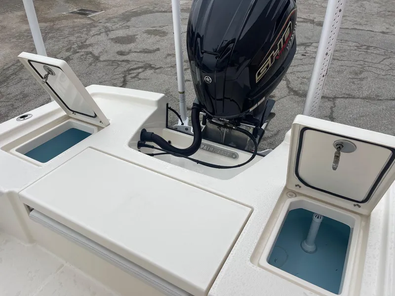 Slide: The Image of 2024 Pathfinder 2200 TRS boat with open storage compartments and outboard motor. - 9