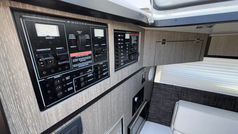 Slide: The Image of Control panel inside a 2023 Monterey 385SS boat cabin, featuring modern switches and gauges. - 31