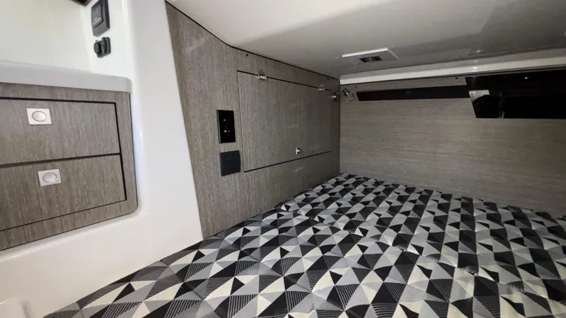 Slide: The Image of 2023 Monterey 385SS cabin interior with geometric-patterned bedding and modern cabinetry. - 38