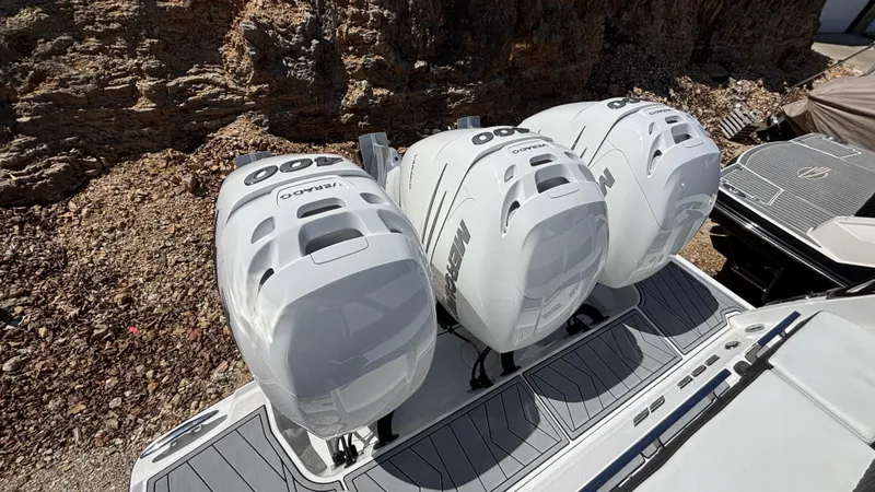 Slide: The Image of 2023 Monterey 385SS boat with triple outboard engines, docked near rocky terrain. - 4