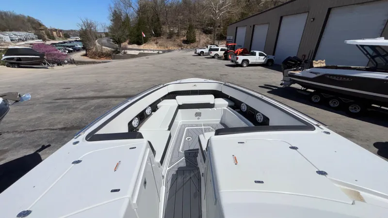 Slide: The Image of 2023 Monterey 385SS boat interior with spacious seating and modern design in a marina setting. - 43