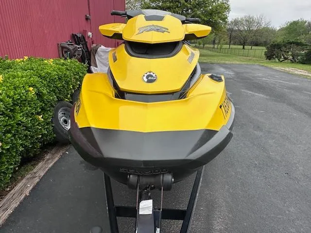 Slide: The Image of Yellow 2011 Sea-Doo RXT 260 jet ski parked on driveway near red building. - 10