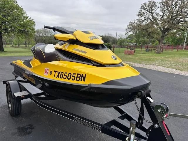 Slide: The Image of 2011 Sea-Doo RXT 260 jet ski in yellow on a trailer, parked outdoors. - 3