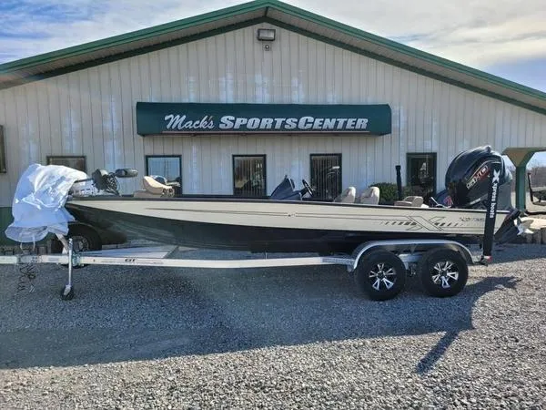Slide: The Image of 2023 Xpress X21 Pro boat at Mack's Sports Center, parked on a gravel lot. - 1