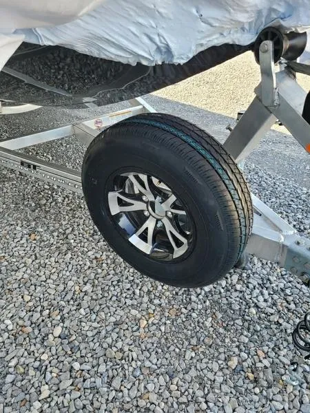 Slide: The Image of 2023 Xpress X21 Pro trailer wheel on gravel surface. - 6