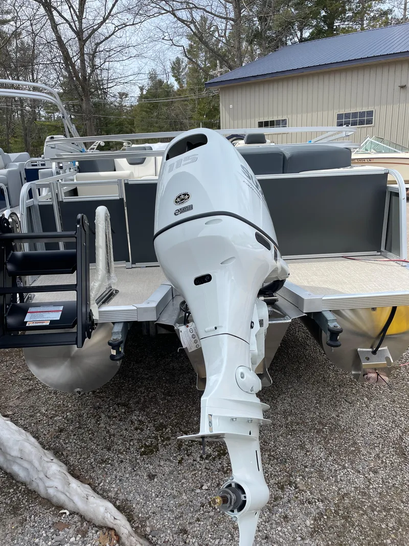 Slide: The Image of 2025 Avalon 23 LSZ Elite pontoon boat with powerful outboard motor, parked outdoors. - 2