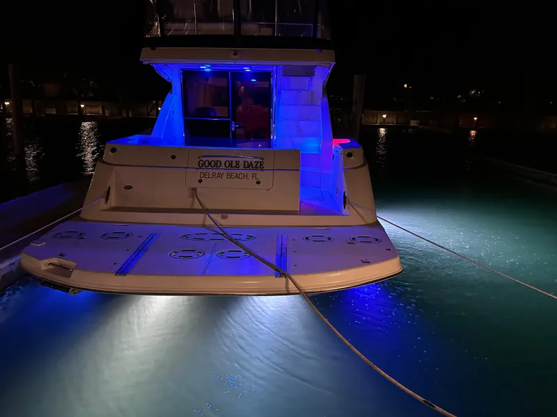 Slide: The Image of 2008 Sea Ray 47 Sedan Bridge yacht illuminated with blue lights at night. - 17