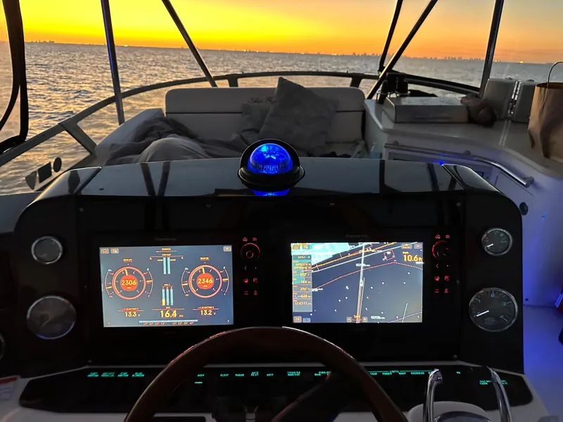 Slide: The Image of 2008 Sea Ray 47 Sedan Bridge helm with sunset view, featuring advanced navigation displays. - 27