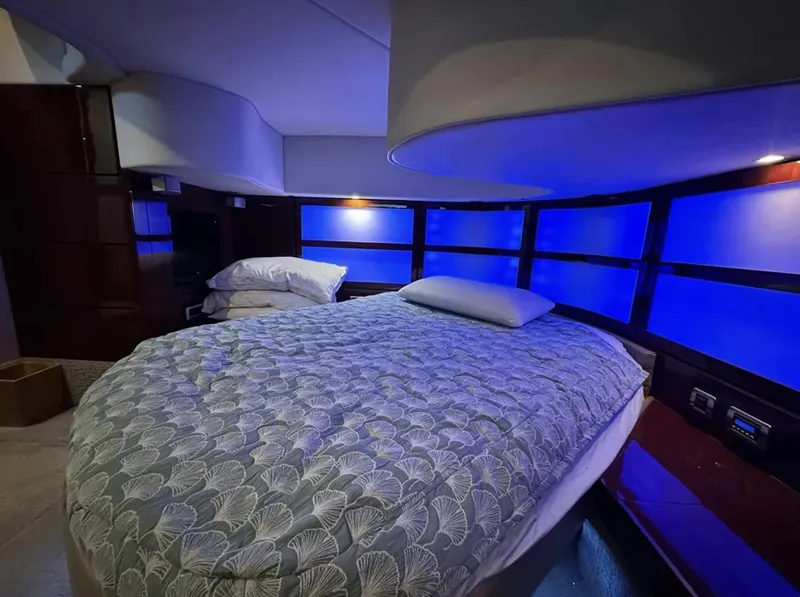 Slide: The Image of Luxurious bedroom interior of 2008 Sea Ray 47 Sedan Bridge yacht with blue ambient lighting. - 35
