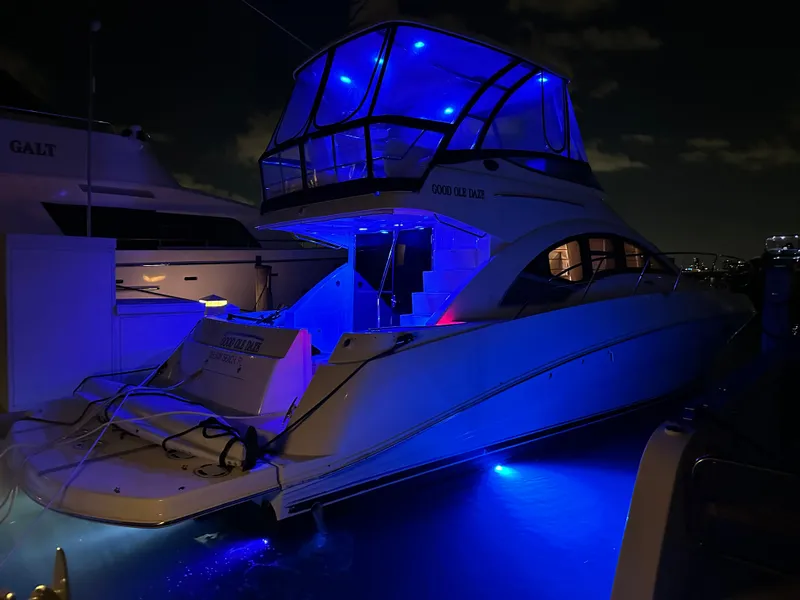 Slide: The Image of 2008 Sea Ray 47 Sedan Bridge yacht illuminated with blue lights at night. - 36