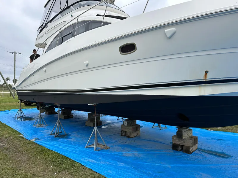 Slide: The Image of 2008 Sea Ray 47 Sedan Bridge yacht on stands, blue tarp underneath, side view. - 5