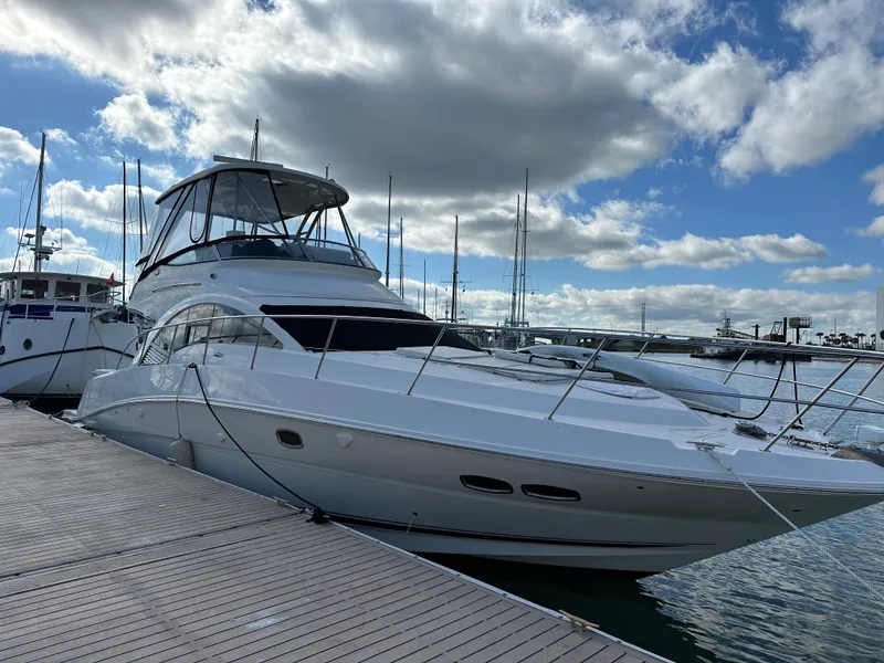 Slide: The Image of 2008 Sea Ray 47 Sedan Bridge yacht docked at marina under cloudy sky. - 9
