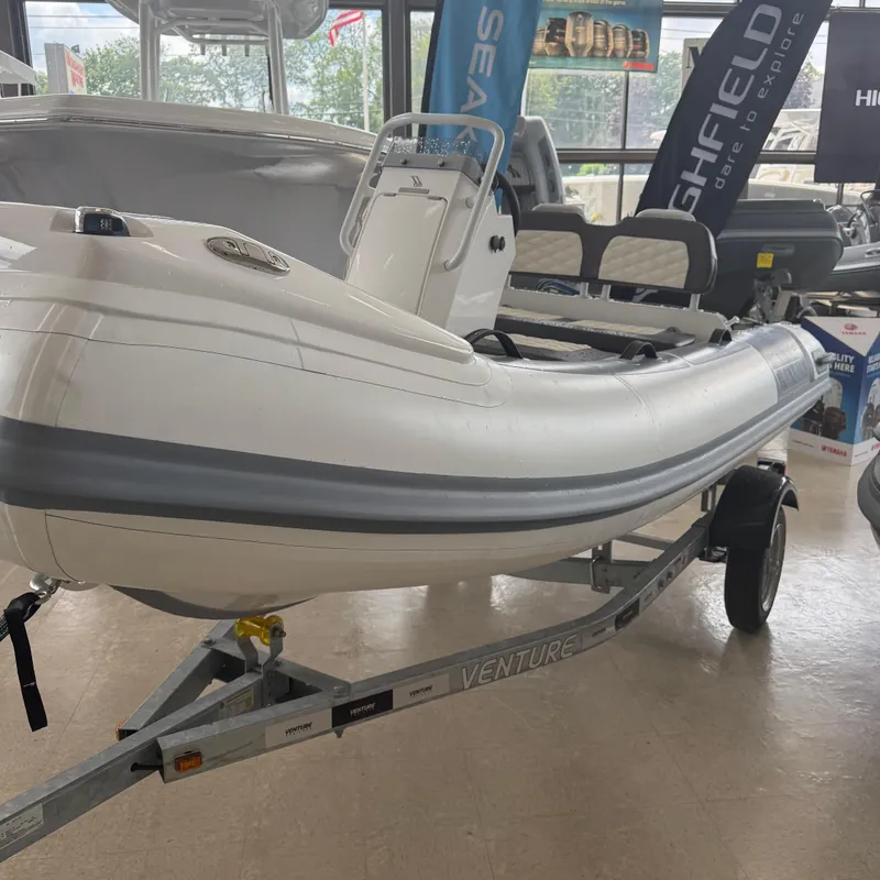 The Image of 2025 Highfield Sport 360 inflatable boat on trailer in showroom. - 0