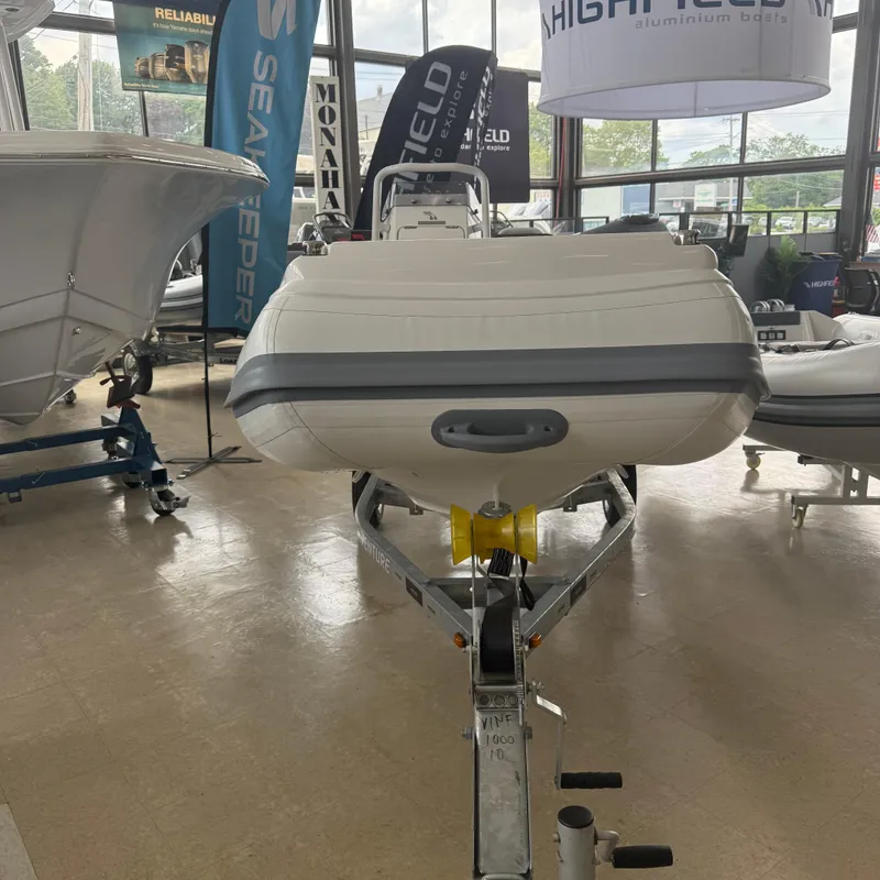 Slide: The Image of 2025 Highfield Sport 360 boat displayed indoors on a trailer. - 2