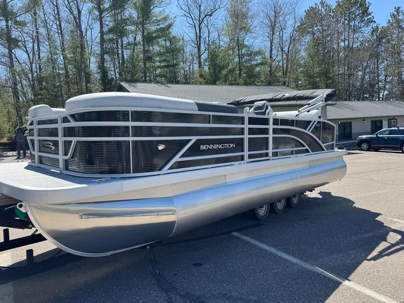 Slide: The Image of 2025 Bennington 22SSB-SPS pontoon boat parked outdoors on a sunny day. - 4