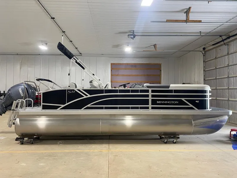 Slide: The Image of 2025 Bennington 22SSB-SPS pontoon boat in a garage, featuring Yamaha outboard motor. - 6