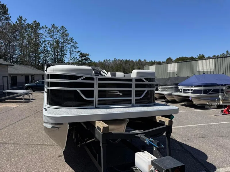 Slide: The Image of 2025 Bennington 22SSB-SPS pontoon boat on trailer in outdoor storage area. - 8